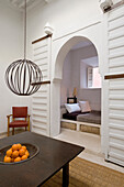 Table, hanging lamp and fruit bowl, oriental-style passageway to cosy seating area