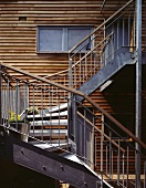 Metal, exterior stairs in front of wooden facade of modern house
