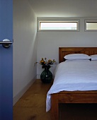 Corner of bedroom with bed beneath narrow window slits