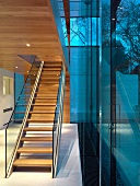 Foyer with staircase and glass balustrade beneath wood-clad ceiling