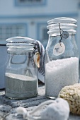 Sand and white gravel in preserving jars with fine wires on lids