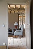 Blick durch die offene Tür ins Landhaus-Wohnzimmer auf einen Ohrenbacken-Sessel