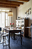 Wooden table and cupboard in dining room with ceiling beams