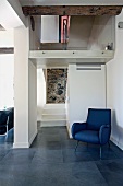 Blauer Sessel im Retrostil in modernem Wohnraum mit offenem Treppenhaus