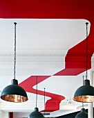Pendant lamps with two-tone shades hang from ceiling in modern colours