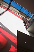 Glass wall with red shadows and glass roof