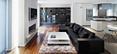 Black leather couch in open-plan, modern living space