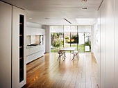 Spacious dining room with modern, open-plan kitchen and terrace in background