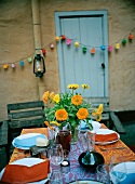 Strauss aus Ringelblumen auf einem gedeckten Tisch im Freien