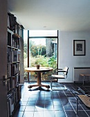 Round table and chair in study with bookcase
