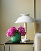 Vase of Pink Peonies on a Side Table with a Lamp