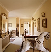 Antique rocking horse and gilt-framed pictured on traditional landing