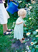 Toddler watering flowers