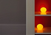 Spherical, yellow lamps on shelves