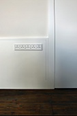 Half-height, white wood panelling and integrated row of plug sockets