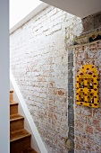 Yellow painted wall cabinet on brick wall of stairwell