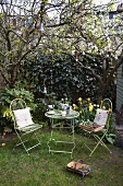 Garden table with two chairs beneath tree with Easter decorations