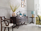 Sideboard and antique chair against wall with stucco ornaments