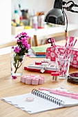 Various pink writing materials on table