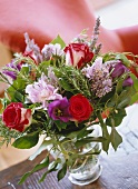 Summer posy with red roses and rosemary in glass vase