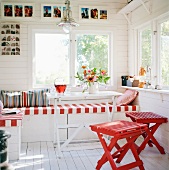 Cozy corner seat and red-lacquered wooden stool in front with a view of the garden