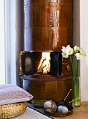 View of blazing fire in an old fireplace and with high-gloss, brown tiles