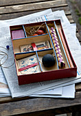 Playing cards in box with various compartments on newspaper