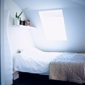 Modern attic with a bed under the window