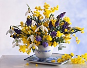 Gelbe und violette Blumen in Porzellanschale