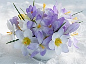 weiße und violette Blumen in Vase auf Spitzendecke