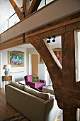 Offener Wohnraum mit moderner Sofagarnitur und Galerie auf Holzkonstruktion