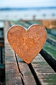 Rusty metal heart on wooden boards