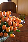 Orangefarbener Tulpenstrauss auf Tisch