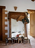 Various ethnic-style wooden footstools in front of full-length mirror in Mediterranean foyer