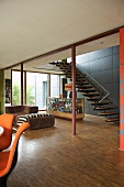 Offener Wohnraum mit Sofa und Theke vor Treppenaufgang