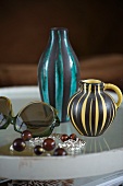 Tray with two different striped vases and sunglasses