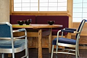 Tea bowls on wooden dining table and upholstered metal-framed chairs