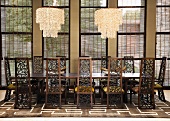 Striking chairs with pierced backs at a long table with modern chandeliers