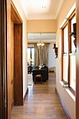 Passage with open doorway and view of armchairs in living room