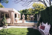 Antique Greek planters in garden in front of pool and house with roofed terrace