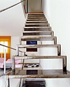 Moderne Stahltreppe an Wand in offenem Wohnzimmer
