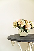 Bouquet of roses in glass vase on vintage table