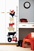 Animals painted next to a yardstick on the wall of a child's room