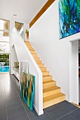 Open-plan foyer with wooden staircase and view of gallery in contemporary building