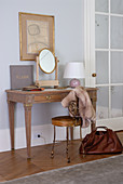 Antique-style dressing table and delicate brass chair in elegant bedroom