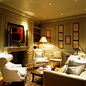 Reading chairs with white fabric upholstery in traditional salon with open fireplace