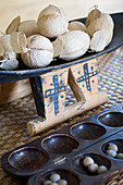 Afrikanische Holzschale mit Bällen aus Naturmaterial und afrikanisches Gesellschaftsspiel (Kalaha) aus dunklem Holz mit Bohnen