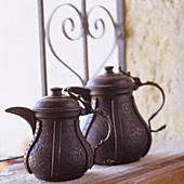 Dark, metal Moroccan teapots on windowsill