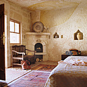Marokkanisches Schlafzimmer mit Teppichen und offenem Kamin in Ecke