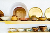 Ethnic earthenware pots on simple wall-mounted shelves